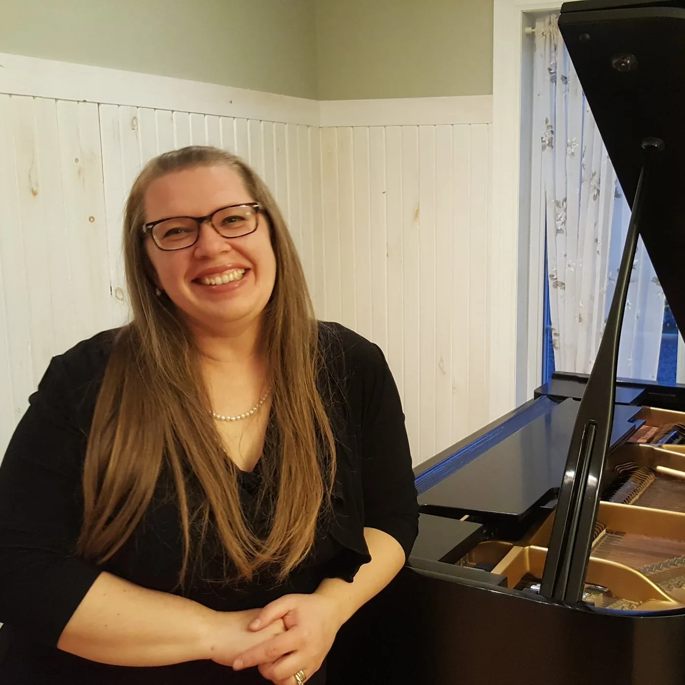 Une musicienne de l'OSJVS souriant à côté d'un piano